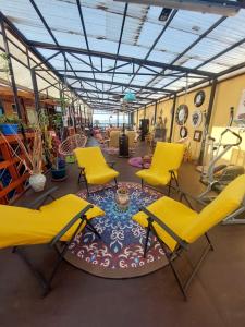 a room with two yellow chairs and a table at Noface 5 in Los Vilos
