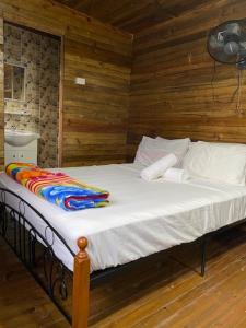 Camp Taveuni في ماتي: سرير كبير في غرفة بجدران خشبية