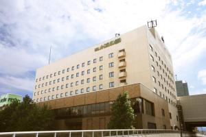 a white building with a green sign on it at Hotel Metropolitan Morioka in Morioka