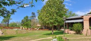 a garden with a table and chairs and a building at La Calma, casa frente al río, gran parque y pileta in Villa Icho Cruz +13 photos
