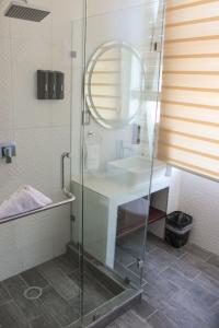 a bathroom with a glass shower with a sink at Hotel Zócalo Chilpancingo in Chilpancingo de los Bravos
