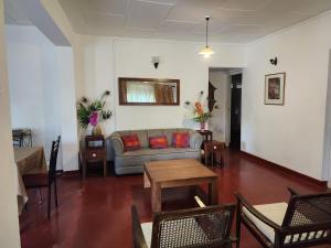 un soggiorno con divano, tavoli e sedie di Ruwanwali Resort a Anuradhapura