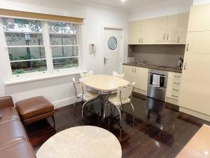 cocina con mesa y sillas en una habitación en East Melbourne unit with courtyard, en Melbourne