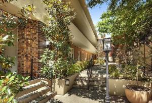 メルボルンにあるEast Melbourne unit with courtyardの通灯と植物のある建物