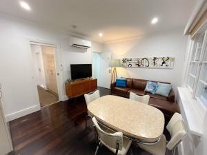 a living room with a table and a couch at East Melbourne unit with courtyard in Melbourne