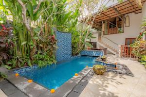 una piscina en medio de un jardín en Bali Akasa Villa en Seminyak