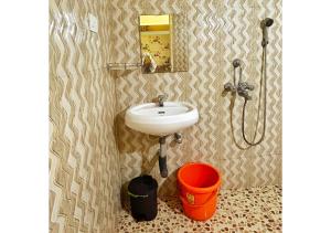 a bathroom with a sink and a bucket at THE MUSAFIR HOSTEL in Anjuna