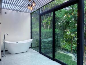 a bathroom with a tub and a large window at Hailin Resort Vangvieng in Vang Vieng