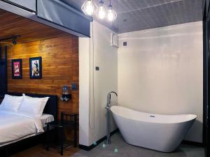 a bathroom with a tub next to a bed at Hailin Resort Vangvieng in Vang Vieng