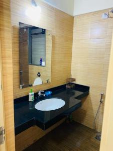a bathroom with a sink and a mirror at Lake View Lavish studio in Lavasa