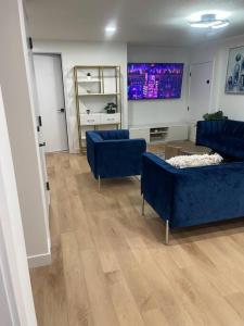 uma sala de estar com dois sofás azuis e uma televisão em Modern 2Bedroom suite in SW Edmonton close to Edmonton International Airport em Edmonton