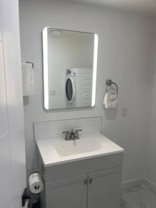 a white bathroom with a sink and a mirror at Modern 2Bedroom suite in SW Edmonton close to Edmonton International Airport in Edmonton