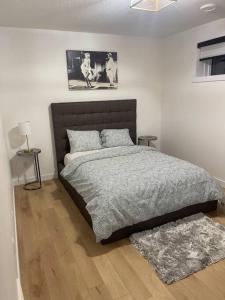 a bedroom with a bed with a gray comforter at Modern 2Bedroom suite in SW Edmonton close to Edmonton International Airport in Edmonton