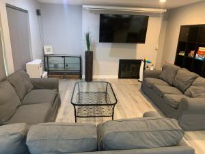 a living room with two couches and a flat screen tv at Family 4BR Home 15 min to Disneyland & Beach in Tustin