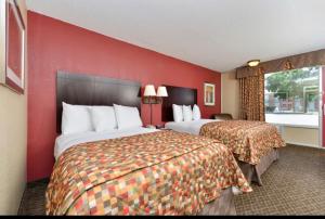 a hotel room with two beds and a red wall at guest inn in Ardmore