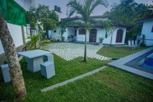 a white house with a table in the yard at Villa 6070 in Galle