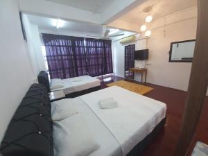 Zimmer mit einem Bett und einem Flachbild-TV in der Unterkunft Musafir Transit Hotel in Nilai