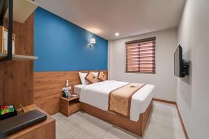 a bedroom with a bed and a blue wall at Bcons PS Hotel and Apartment- Newly Opened Hotel in Bien Hoa