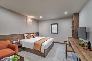 Bcons PS Hotel and Apartment- Newly Opened Hotel في بين هوا: غرفة فندق بسرير وتلفزيون