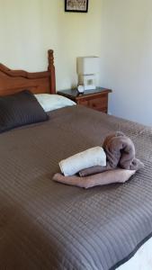Una cama con dos toallas y un animal de peluche. en Finca pajaritos, en Las Palmas de Gran Canaria