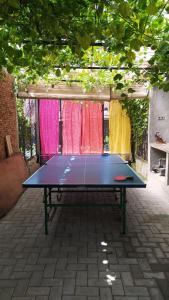 a ping pong table sitting in a courtyard with curtains at Villa di Bukit Lawang: LocalDailyLife, near Jungle in Bukit Lawang