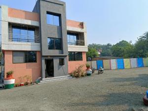 a building that is sitting in a parking lot at RJ Villa farmhouse in Daman