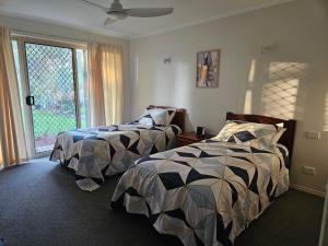 een slaapkamer met 2 bedden en een raam bij Gungurru in Corowa