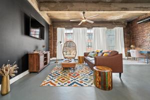 a living room with a couch and a ceiling fan at Charming Boho Loft on Historic Morris Ave in Birmingham