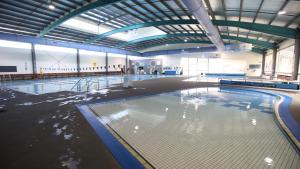 an empty swimming pool in a large building at Beachcomber Holiday Units in Lakes Entrance