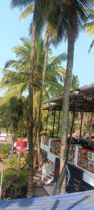 a group of palm trees next to a restaurant at Hotel Khushi Waves in Arpora