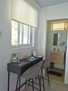 a dining room table with two chairs and a mirror at Fare Kairos in Uturoa