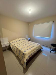 a bedroom with a bed and a large window at Reserva Tajamar in Alta Gracia