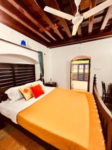 a bedroom with a large bed with a ceiling fan at Srivilas in Pudunagaram