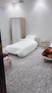 a bedroom with a large white bed and a carpet at فيلا in Hafr Al-Batin