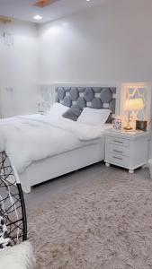 1 dormitorio con 1 cama blanca grande y escritorio en فيلا en Hafr Al Batin