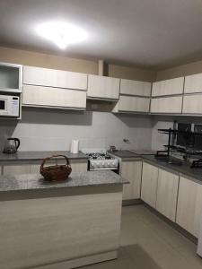 a kitchen with white cabinets and a basket on the counter at Reserva Tajamar in Alta Gracia