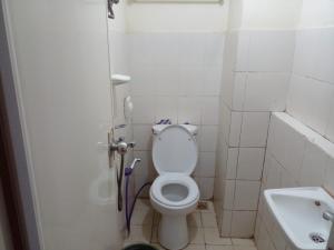 a small bathroom with a toilet and a sink at GREENROOM Apartemen Bogor Valley in Kalibata 1