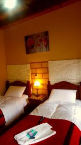 una habitación de hotel con 2 camas y una toalla en la cama en POSADITA LOS ALAMOS estamos en San Isidro 8km pasando Iruya solo se hace a pie TURISMO AVENTURA. en Iruya