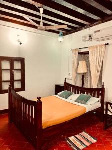 1 dormitorio con 1 cama grande con sábana naranja en Srivilas, en Pudunagaram