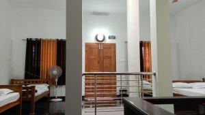 um quarto com duas camas e um relógio na parede em Ammu's home stay em Panamaram