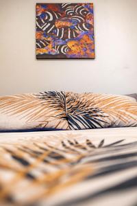 una pintura colgada en una pared junto a una cama en Croton House, Nadi, en Nadi