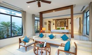 a bedroom with a bed and a couch and a table at Cam Ranh Riviera Beach Resort & Spa in Cam Ranh