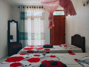 - 2 lits dans une chambre ornée de fleurs rouges dans l'établissement Pleasure Mount Homestay, à Ella 17 autres photos