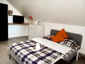 een slaapkamer met een bed met oranje kussens erop bij Miko apartamentai in Kaunas