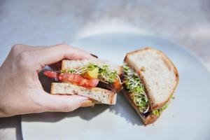 a person holding a sandwich in their hand at NOHGA HOTEL KIYOMIZU KYOTO in Kyoto