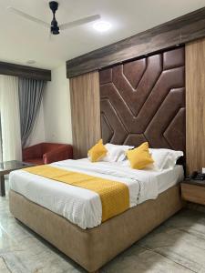 a bedroom with a large bed with a wooden headboard at Hotel krishna in Nizāmābād