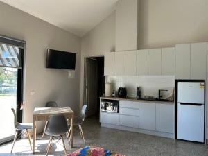 a kitchen with white cabinets and a table and chairs at Pelicans on the Darling in Wentworth