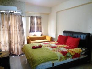 a bedroom with a large bed with red pillows at GREENROOM Apartemen Bogor Valley in Kalibata 1