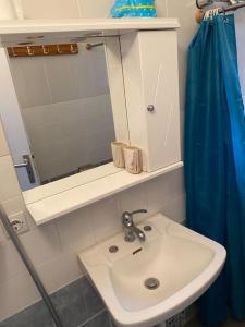 a bathroom with a sink and a mirror at Tzouliano’s Apartment in Sarandë +13 photos