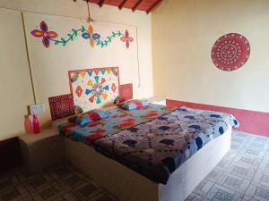 a bedroom with a bed with a quilt on it at Rann Kutch Resort in Dhordo